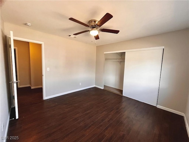 unfurnished bedroom featuring dark hardwood / wood-style flooring, ceiling fan, and a closet