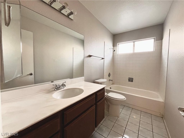 full bathroom with tile patterned floors, vanity, a textured ceiling, toilet, and tiled shower / bath