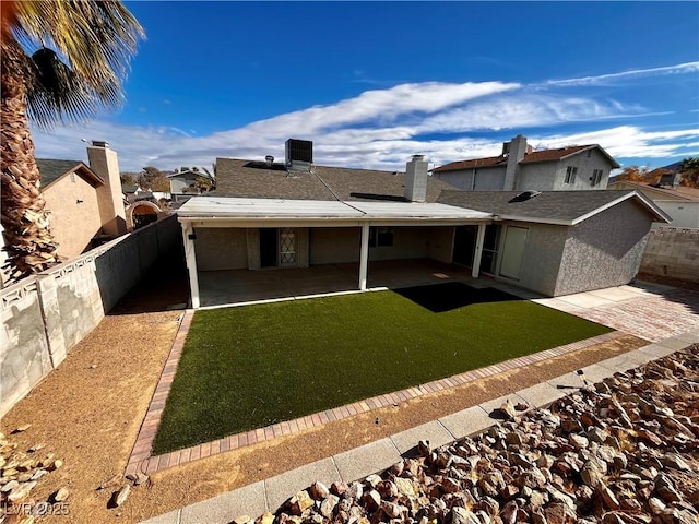 back of property with central AC, a patio area, and a lawn