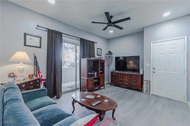 living room featuring ceiling fan and light hardwood / wood-style floors