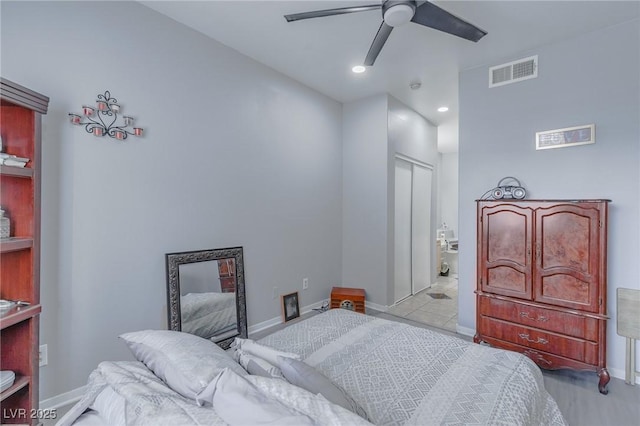 bedroom featuring a closet, ensuite bath, and ceiling fan