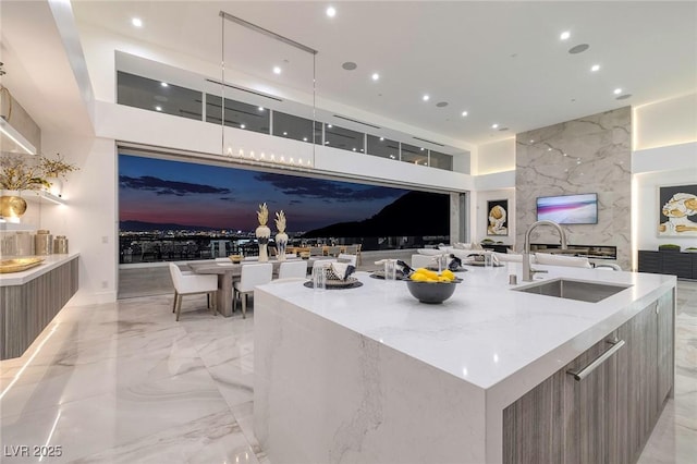 kitchen featuring light stone counters, sink, and a spacious island