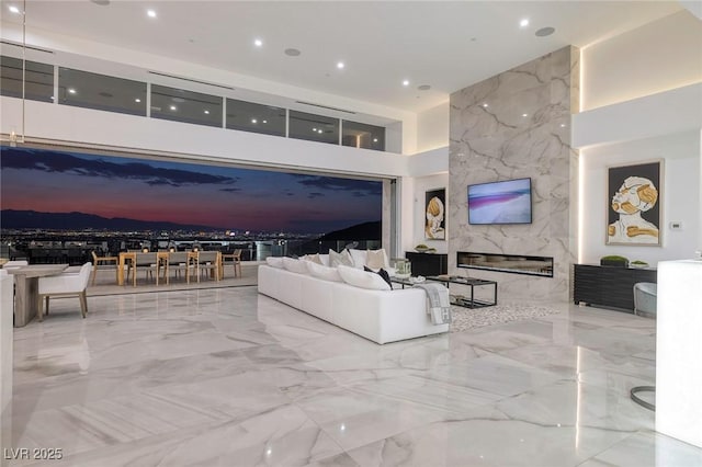 living room with a high end fireplace and a high ceiling