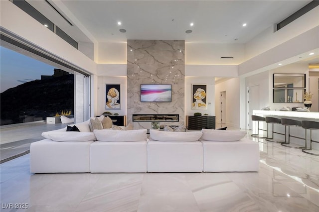 living room with a towering ceiling and a high end fireplace