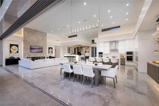 dining space with a fireplace and a high ceiling