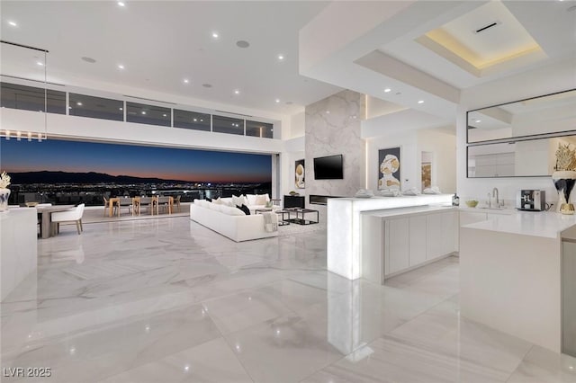 kitchen featuring kitchen peninsula, white cabinetry, and sink