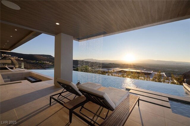 patio terrace at dusk with a water and mountain view