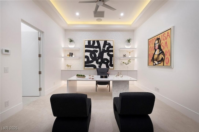 office with ceiling fan, light carpet, and a tray ceiling