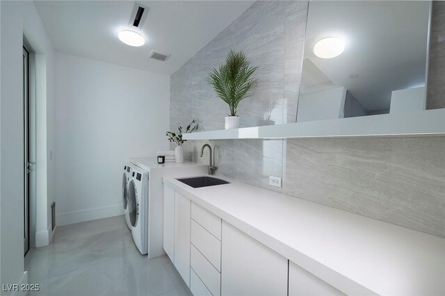 washroom featuring cabinets, separate washer and dryer, sink, and tile walls