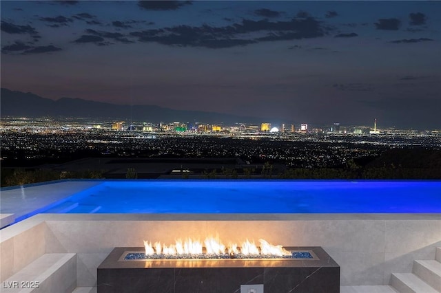 pool at night with an outdoor fire pit