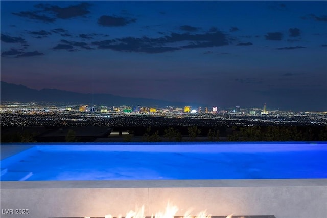 view of pool at twilight