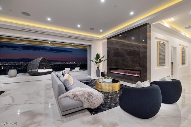 cinema room featuring a tray ceiling and a fireplace