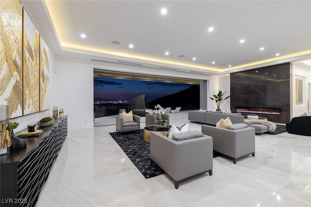 living room with a raised ceiling and a fireplace