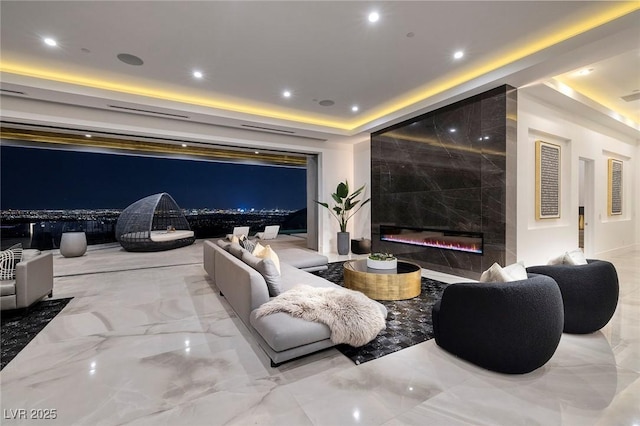 cinema room with a premium fireplace and a tray ceiling