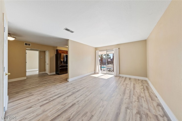 kitchen featuring appliances with stainless steel finishes, light hardwood / wood-style flooring, and light stone counters