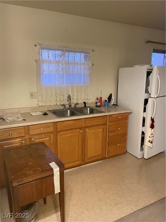 kitchen featuring white fridge and sink