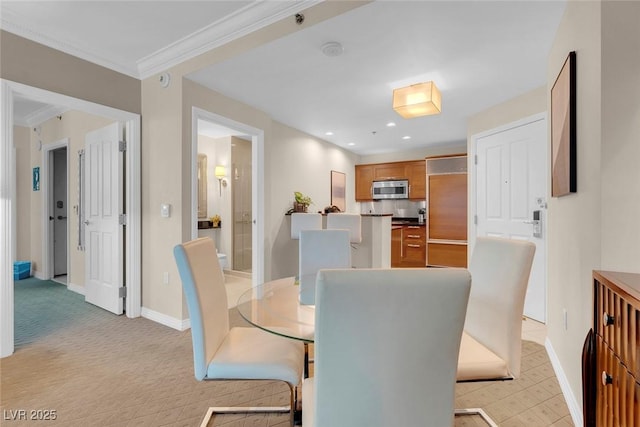 dining room with light colored carpet and ornamental molding