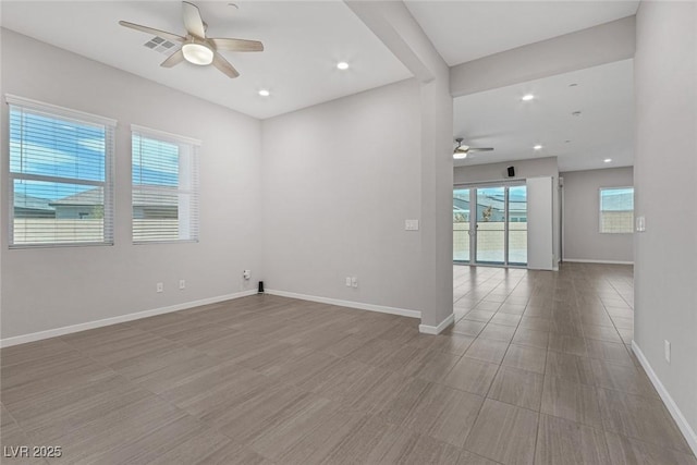 empty room with ceiling fan and a healthy amount of sunlight