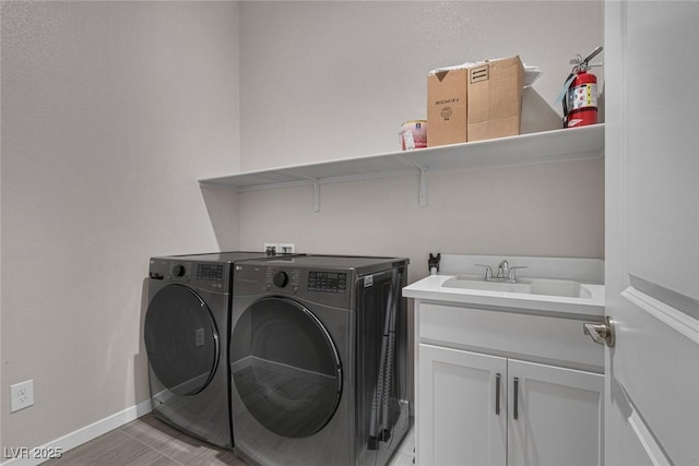 washroom featuring cabinets, separate washer and dryer, and sink