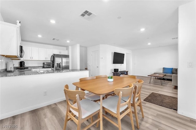 dining space featuring light wood-type flooring