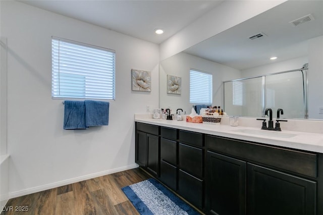 bathroom featuring wood-type flooring, an enclosed shower, vanity, and a wealth of natural light