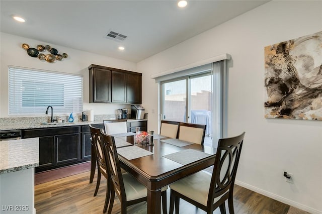 dining space with hardwood / wood-style flooring and sink