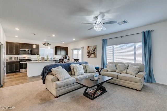 carpeted living room featuring ceiling fan