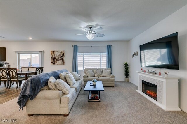 carpeted living room with ceiling fan