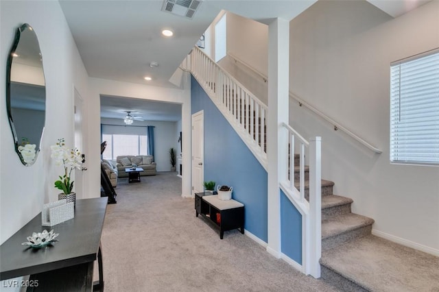 staircase featuring ceiling fan and carpet floors