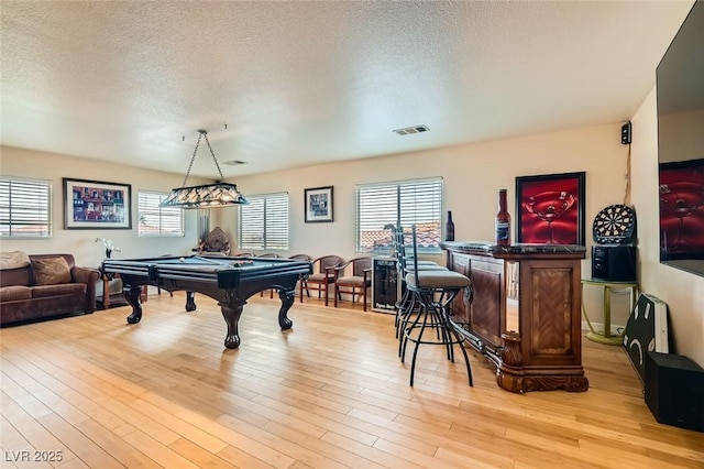 recreation room featuring billiards, light hardwood / wood-style flooring, and a textured ceiling