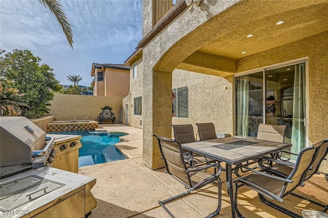 view of patio / terrace with grilling area and a pool with hot tub