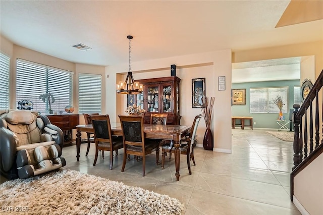 tiled dining space featuring an inviting chandelier