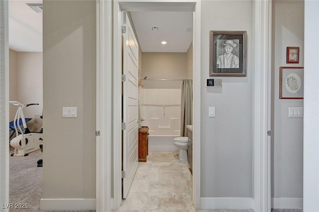 bathroom featuring shower / bath combination with curtain and toilet