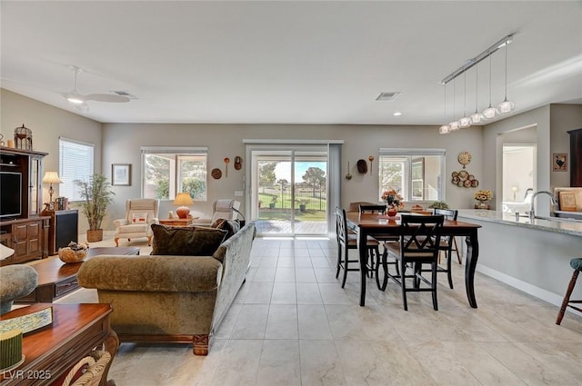 living room with sink, light tile patterned flooring, and track lighting