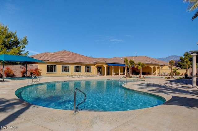 view of pool with a patio area and a mountain view