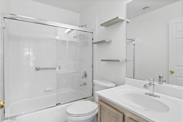 full bathroom featuring vanity, toilet, and bath / shower combo with glass door