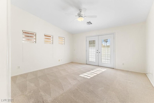 unfurnished room featuring french doors, light colored carpet, vaulted ceiling, and ceiling fan