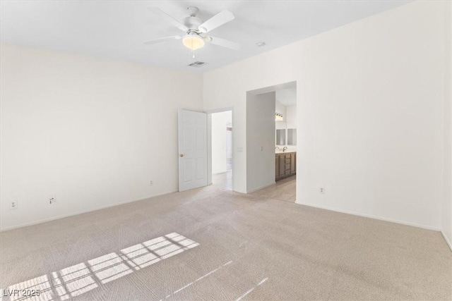 spare room featuring light carpet and ceiling fan