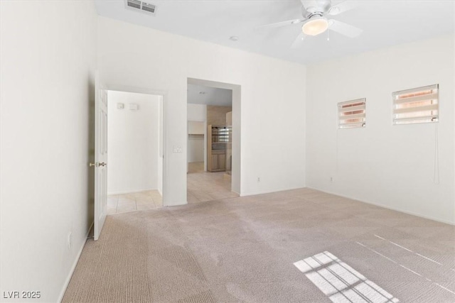 spare room featuring ceiling fan and light colored carpet