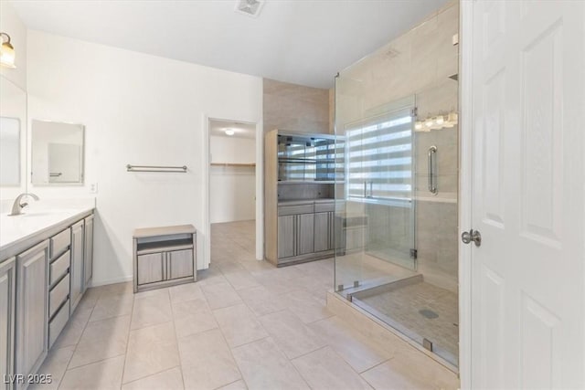 bathroom featuring tile patterned flooring, vanity, and a shower with door