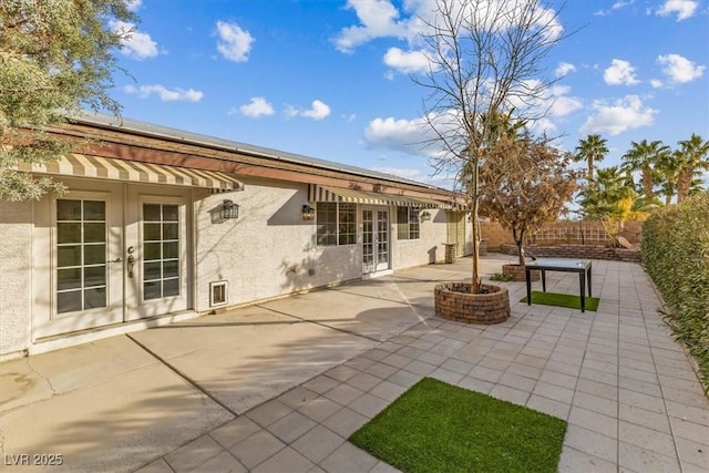 rear view of house featuring a patio area, french doors, and a fire pit