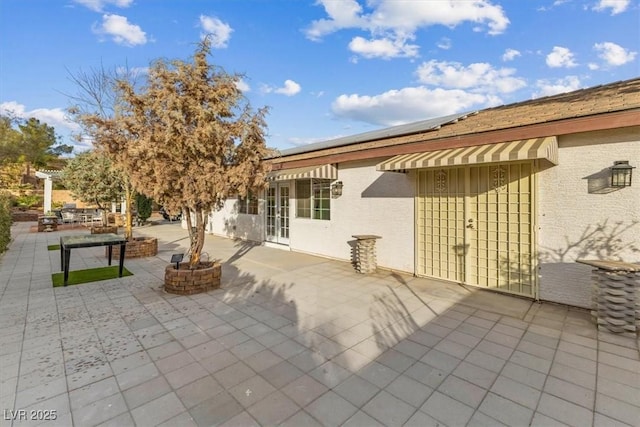 rear view of property with a patio and a fire pit