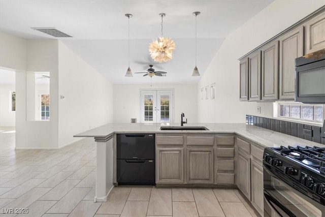 kitchen with kitchen peninsula, vaulted ceiling, ceiling fan, black appliances, and sink