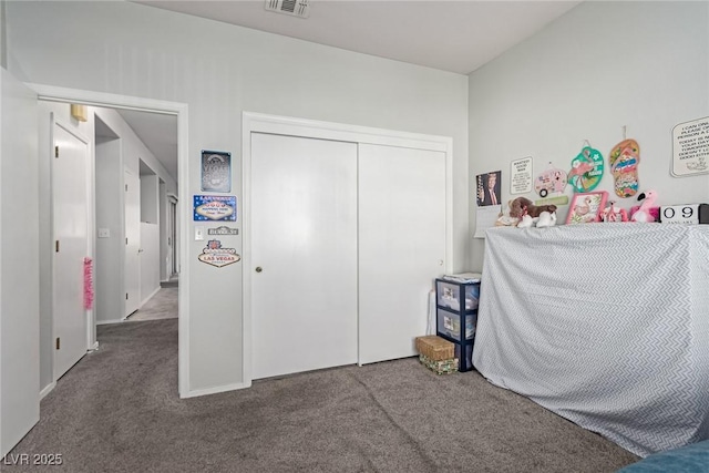 bedroom with dark carpet and a closet