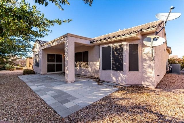 rear view of property with cooling unit and a patio