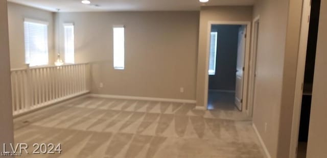 spare room featuring light colored carpet