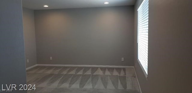 unfurnished room with dark colored carpet