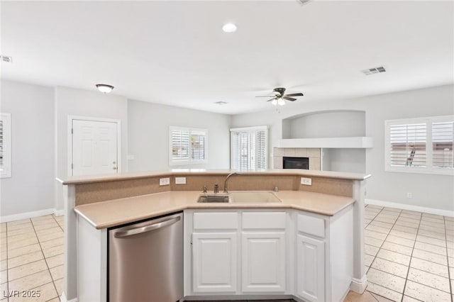 kitchen with a healthy amount of sunlight, sink, dishwasher, white cabinetry, and an island with sink