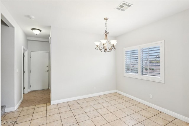 spare room with light tile patterned flooring and a chandelier