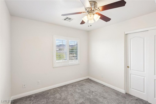 carpeted spare room with ceiling fan